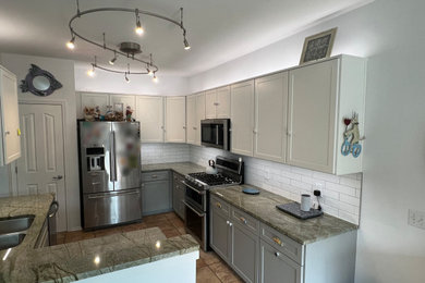 Eat-in kitchen - mid-sized traditional l-shaped eat-in kitchen idea in Cleveland with shaker cabinets, white backsplash and subway tile backsplash