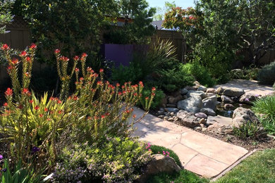 Inspiration for a large transitional backyard partial sun garden in San Francisco with with pond and natural stone pavers.