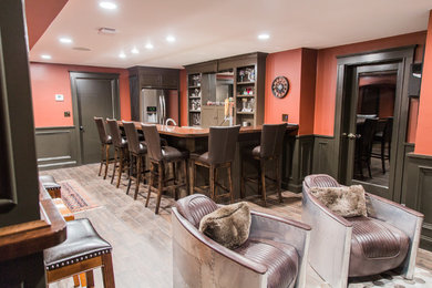 Huge elegant underground laminate floor and brown floor basement photo in Boston with red walls