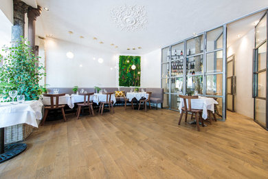 Cette image montre une salle à manger design de taille moyenne avec un mur blanc et un sol en bois brun.