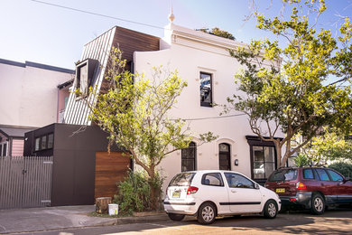 Diseño de fachada de casa multicolor moderna de tamaño medio de tres plantas con revestimiento de madera y tejado de varios materiales