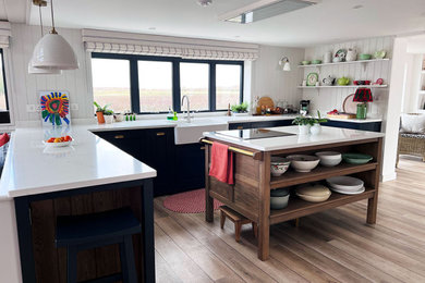 Inspiration for a large nautical open plan kitchen in Other with a belfast sink, shaker cabinets, blue cabinets, quartz worktops, white splashback, stainless steel appliances, an island and white worktops.