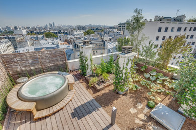 Inspiration for a mid-sized country rooftop and rooftop deck in Paris with with privacy feature and wood railing.