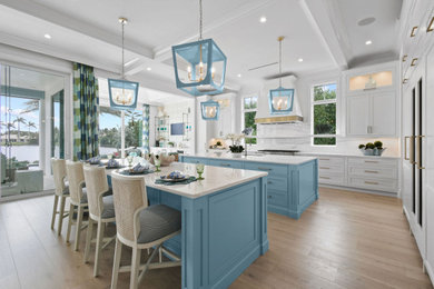 Example of a large beach style kitchen design in Other with beaded inset cabinets and two islands
