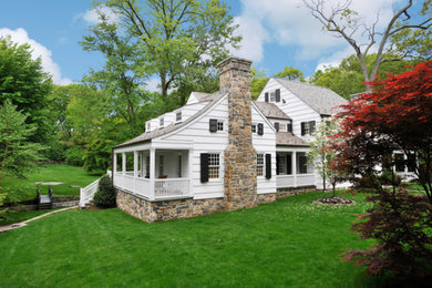 Inspiration for a mid-sized timeless white two-story wood gable roof remodel in New York