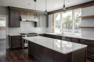 Large transitional dark wood floor and brown floor kitchen photo in Boston with an undermount sink, recessed-panel cabinets, dark wood cabinets, quartz countertops, white backsplash, ceramic backsplash, stainless steel appliances and an island