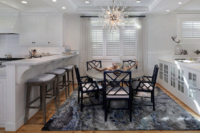 Kitchen/dining room combo - mid-sized coastal light wood floor kitchen/dining room combo idea in San Diego with gray walls, a standard fireplace and a stone fireplace
