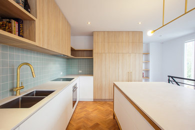 This is an example of a contemporary kitchen in Melbourne with green splashback and with island.