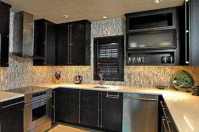 Eat-in kitchen - contemporary u-shaped porcelain tile eat-in kitchen idea in New Orleans with an undermount sink, flat-panel cabinets, dark wood cabinets, quartz countertops, gray backsplash, glass tile backsplash and stainless steel appliances