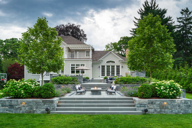 Large trendy backyard patio photo in Boston with a fire pit
