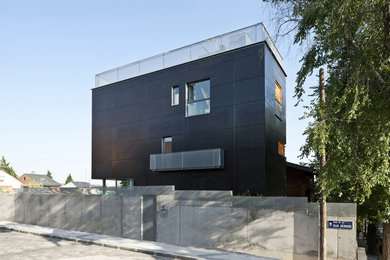 Imagen de fachada de casa negra urbana de tamaño medio de tres plantas con revestimiento de madera, tejado plano y tejado de varios materiales