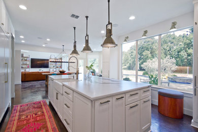 Example of a large transitional concrete floor and gray floor eat-in kitchen design in Houston with a farmhouse sink, shaker cabinets, white cabinets, quartz countertops, white backsplash, brick backsplash, paneled appliances, an island and white countertops