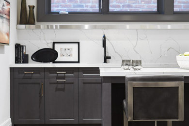 Wet bar - mid-sized contemporary u-shaped dark wood floor wet bar idea in Toronto with an undermount sink, recessed-panel cabinets, gray cabinets, white backsplash and white countertops