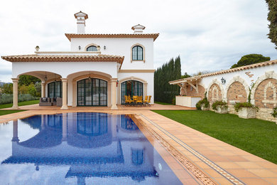 Esempio di una piscina naturale mediterranea rettangolare di medie dimensioni e dietro casa con fontane e piastrelle
