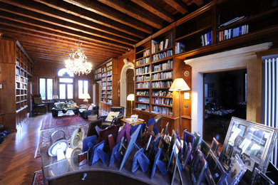 Diseño de sala de estar con biblioteca clásica con suelo de madera oscura, vigas vistas, madera y alfombra
