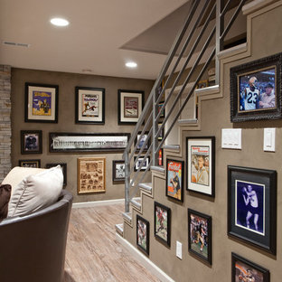 Imagen de sótano en el subsuelo clásico renovado, grande, con chimenea tradicional, paredes marrones, suelo de madera en tonos medios y suelo marrón