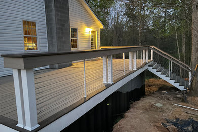 Deck - huge modern side yard ground level cable railing deck idea in Richmond