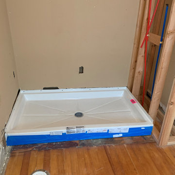 Install new acrylic shower pan, run water supply lines and drain