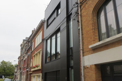 Modelo de fachada de casa negra y gris actual grande con revestimientos combinados, tejado plano y tejado de varios materiales
