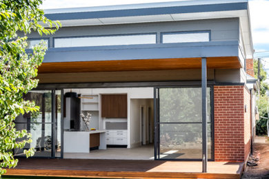 Diseño de fachada de casa roja y blanca contemporánea de tamaño medio de una planta con revestimiento de ladrillo, tejado plano, tejado de metal y tablilla