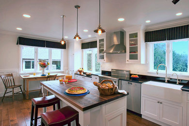 Enclosed kitchen - small traditional l-shaped medium tone wood floor enclosed kitchen idea in San Francisco with a farmhouse sink, beaded inset cabinets, white cabinets, granite countertops, white backsplash, ceramic backsplash and stainless steel appliances
