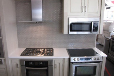 Kitchen photo in Other with white cabinets, granite countertops, gray backsplash and stainless steel appliances