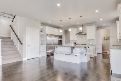 Mid-sized u-shaped light wood floor and brown floor open concept kitchen photo in Other with a drop-in sink, beaded inset cabinets, white cabinets, granite countertops, stainless steel appliances and an island