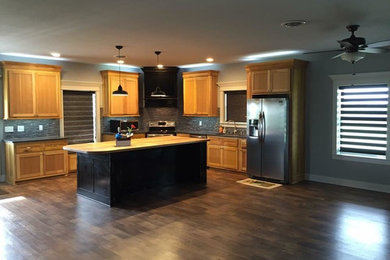 Inspiration for a large farmhouse l-shaped brown floor and dark wood floor open concept kitchen remodel in Chicago with an undermount sink, shaker cabinets, light wood cabinets, wood countertops, gray backsplash, matchstick tile backsplash, stainless steel appliances and an island
