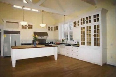 Open concept kitchen - mid-sized l-shaped medium tone wood floor open concept kitchen idea in New York with beaded inset cabinets, white cabinets, wood countertops, yellow backsplash, stainless steel appliances and an island