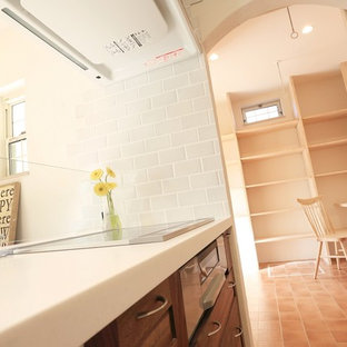 Mid-sized scandinavian kitchen pantry pictures - Inspiration for a mid-sized scandinavian single-wall linoleum floor and brown floor kitchen pantry remodel in Nagoya with an integrated sink, beaded inset cabinets, dark wood cabinets, solid surface countertops, white backsplash, ceramic backsplash, stainless steel appliances and an island