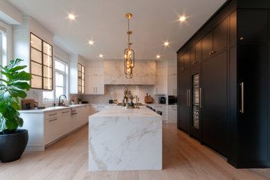 Eat-in kitchen - large 1950s u-shaped light wood floor and brown floor eat-in kitchen idea in Toronto with an undermount sink, recessed-panel cabinets, white cabinets, solid surface countertops, white backsplash, stone slab backsplash, paneled appliances, an island and white countertops