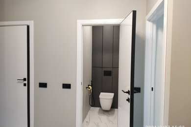 サンクトペテルブルクにあるお手頃価格の小さなコンテンポラリースタイルのおしゃれなトイレ・洗面所 (フラットパネル扉のキャビネット、壁掛け式トイレ、グレーの壁、磁器タイルの床) の写真