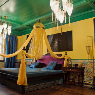 Idee per una camera matrimoniale etnica con pareti gialle, pavimento in legno massello medio e pavimento marrone