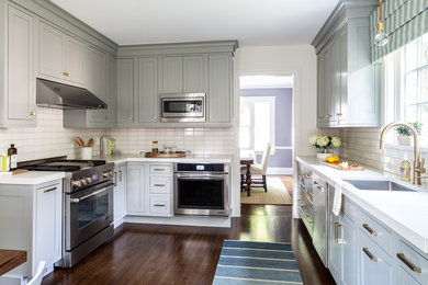 Inspiration for a small transitional u-shaped separate kitchen in New York with an undermount sink, shaker cabinets, grey cabinets, quartz benchtops, white splashback, ceramic splashback, stainless steel appliances, dark hardwood floors, no island, brown floor and white benchtop.