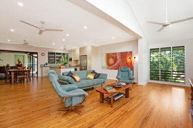 Design ideas for a mid-sized tropical open concept family room in Darwin with beige walls, light hardwood floors and brown floor.