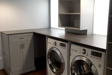 Inspiration for a large timeless dark wood floor utility room remodel in Chicago with gray cabinets, white walls and a side-by-side washer/dryer