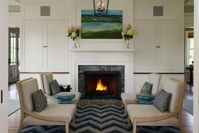 Mid-sized trendy formal and open concept medium tone wood floor living room photo in Portland Maine with a standard fireplace, a stone fireplace, a concealed tv and green walls