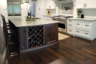 Trendy single-wall bamboo floor and brown floor kitchen pantry photo in Chicago with recessed-panel cabinets, white cabinets, solid surface countertops, white backsplash, ceramic backsplash, stainless steel appliances, an island and white countertops
