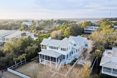 Dreistöckiges Maritimes Einfamilienhaus mit weißer Fassadenfarbe, Blechdach und grauem Dach in Charleston