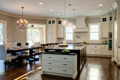 Example of a large transitional l-shaped dark wood floor eat-in kitchen design in Chicago with an undermount sink, beaded inset cabinets, white cabinets, granite countertops, white backsplash and paneled appliances