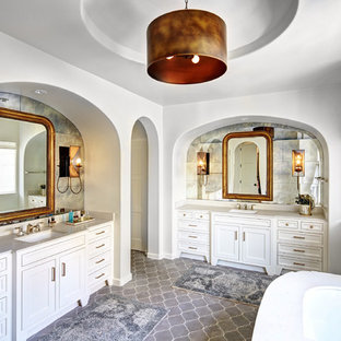 Inspiration pour une grande salle de bain principale méditerranéenne avec des portes de placard blanches, un lavabo encastré, une baignoire encastrée, un mur blanc, un sol en carreau de terre cuite, un plan de toilette en quartz modifié, un carrelage gris, des carreaux de béton et un placard avec porte à panneau encastré.