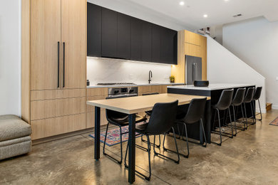 Mid-sized minimalist concrete floor open concept kitchen photo in Chicago with an undermount sink, flat-panel cabinets, stainless steel appliances and an island