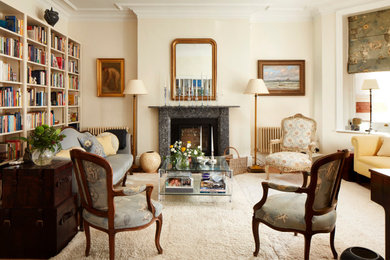 Inspiration for a medium sized eclectic formal enclosed living room in London with beige walls, a standard fireplace, a stone fireplace surround and beige floors.
