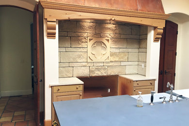 Kitchen - mediterranean terra-cotta tile and multicolored floor kitchen idea in Denver with a farmhouse sink, medium tone wood cabinets, soapstone countertops, beige backsplash, stone slab backsplash and stainless steel appliances