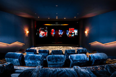 Photo of a large contemporary enclosed home cinema in London with blue walls, carpet and a projector screen.