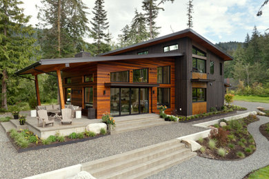 Inspiration for a large modern two-story wood house exterior remodel in Seattle with a metal roof and a black roof