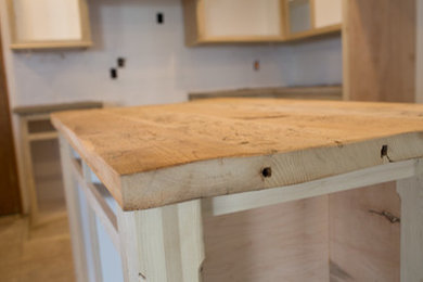 Example of a mid-sized cottage u-shaped eat-in kitchen design in Other with a farmhouse sink, shaker cabinets, white cabinets, concrete countertops, stainless steel appliances and an island