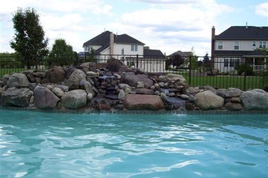 Mid-sized elegant backyard brick and custom-shaped lap pool fountain photo in Philadelphia