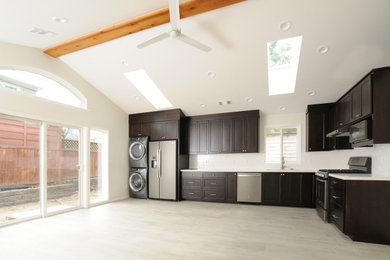 Example of a small trendy l-shaped porcelain tile, gray floor and vaulted ceiling open concept kitchen design in Other with an undermount sink, shaker cabinets, dark wood cabinets, quartz countertops, white backsplash, subway tile backsplash, stainless steel appliances, no island and white countertops
