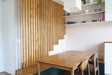 Cette photo montre une salle à manger tendance avec un mur rose et un sol en bois brun.